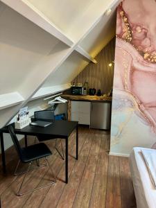 Habitación con escritorio negro y mesa. en Casa Sophie, en Giethoorn