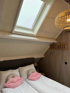 a bedroom with a bed with pink pillows on it at Casa Sophie in Giethoorn