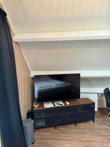 een woonkamer met een tv en een tafel bij Casa Sophie in Giethoorn