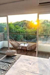 a bedroom with a balcony with a bed and chairs at Lofts Terra Nuevo Vallarta in Nuevo Vallarta