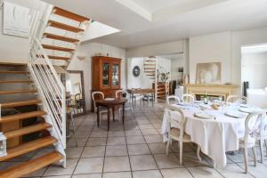 a dining room with a table and chairs and a staircase at Charming house with garden in Sèvres - Welkeys in Sèvres