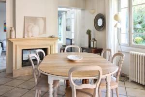 a dining room with a table and chairs and a fireplace at Charming house with garden in Sèvres - Welkeys in Sèvres