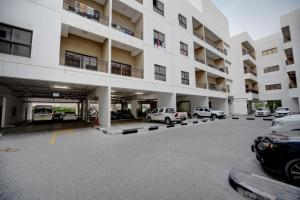 un grand bâtiment avec des voitures garées sur le parking dans l'établissement City Stay Residences - Serviced Apartments DIP, à Dubaï