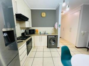 a kitchen with a washing machine and a dishwasher at 361 On Sunset in Sandton