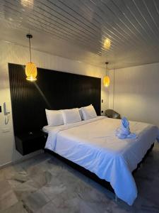 a bedroom with a large white bed with two lights at Hotel Celeste Inn Chinauta- Fusagasugá in Chinauta