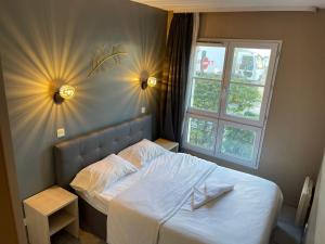 - une chambre avec un lit blanc et une fenêtre dans l'établissement APPARTEMENT NEAR DISNEYLAND, à Serris