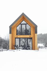 a wooden house with windows in the snow at Hill & Chill Kudowa Zdrój in Kudowa-Zdrój