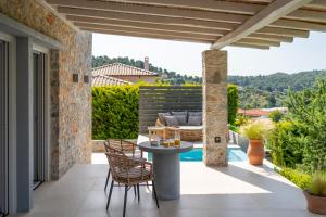 a patio with a table and chairs and a couch at Stone build suite with private pool in Kolios