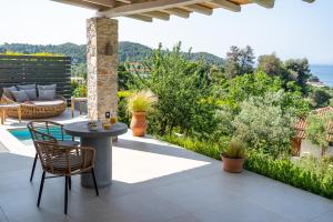 a patio with a table and chairs and the ocean at Stone build suite with private pool in Kolios