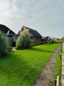 a yard with green grass and houses at Casa Sophie in Giethoorn