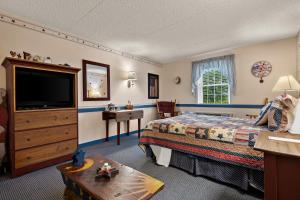 um quarto de hotel com uma cama e uma televisão em Country Living Inn em Lancaster