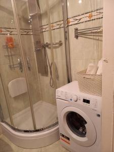 a bathroom with a shower and a washing machine at Apartamenty - MI Stare Miasto in Warsaw