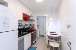 a kitchen with white cabinets and a white counter top at Sunset Urca - Piscina, Garagem e Conforto in Rio de Janeiro