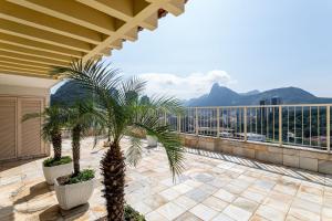 een balkon met palmbomen en uitzicht op de bergen bij Sunset Urca - 2 Hóspedes, Conforto e lazer in Rio de Janeiro