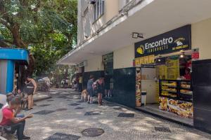 een groep mensen die buiten een winkel staan bij Sunset Urca - 2 Hóspedes, Conforto e lazer in Rio de Janeiro