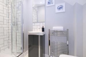 a white bathroom with a shower and a sink at The Northern House in Aberdeen