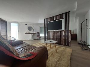a living room with a couch and a flat screen tv at Suite relax in Pontevedra