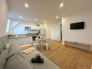 a living room with a couch and a table and a kitchen at ღ Fabrik • Parking sécurisé & Wifi fibre in Douai