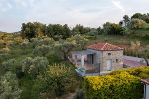 a house in the middle of a field with trees at Stone build suite with private pool in Kolios