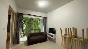 ein Wohnzimmer mit einem Stuhl und einem Fenster in der Unterkunft Phuket naka Condon-13-45免费高速上网免费停车位 in Phuket