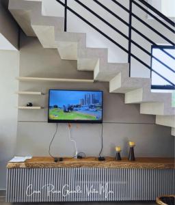sala de estar con TV y escalera en Casa confortável com 2 quartos e 1 suíte, pertinho do Mar, Praia Grande - Beto Carrero, Penha SC, en Penha