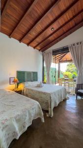 a bedroom with two beds and a table and chairs at Reduto do Alto in Búzios