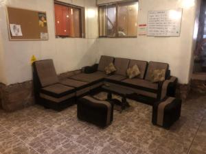 uma sala de estar com um sofá e uma cadeira em Intihuatana Hostel em Pisac