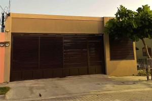 un edificio con una grande porta del garage di Casa Alma a Liberia