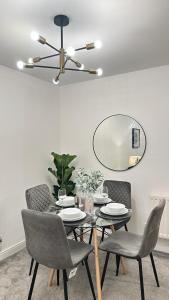 a dining room with a table with chairs and a mirror at Superb & Stylish - Gated Community - Free Parking in Hatfield