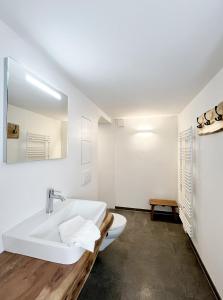 a white bathroom with a sink and a mirror at Ferienhaus Zum Lochstein - FW Gesindehaus in Sankt Andreasberg