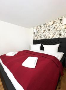 a bedroom with a red bed with white pillows at Ferienhaus Zum Lochstein - FW Gesindehaus in Sankt Andreasberg