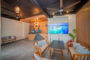 een lobby met een tafel en stoelen en een bar bij Whaleshark Beach in Dhigurah