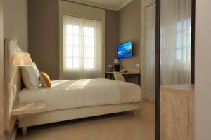 a bedroom with a bed and a desk and a television at Bergamo Inn 43 in Bergamo