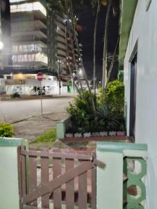 a wooden bench in front of a building at night at Apartamento na Praia in Torres