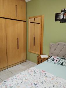 a bedroom with a bed and two cupboards at Apartamento na Praia in Torres