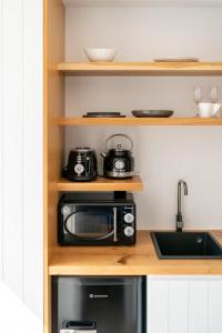 a kitchen with a toaster oven and a microwave at Stone build suite with private pool in Kolios