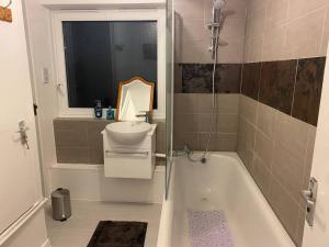 a bathroom with a bath tub and a sink at 2 bedroom flat Camberwell grove in London