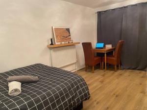 a bedroom with a bed and a table with a laptop at 2 bedroom flat Camberwell grove in London