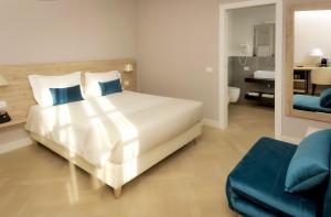 a bedroom with a large white bed with blue pillows at Bergamo Inn 43 in Bergamo