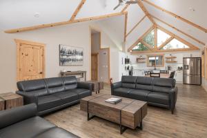 ein Wohnzimmer mit schwarzen Ledermöbeln und eine Küche in der Unterkunft Lazy Moose in Valemount