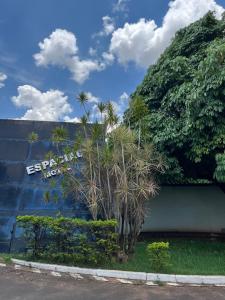 uma parede com palmeiras em frente a um edifício em Espacial Motel em Araçatuba