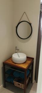 a bathroom with a sink and a mirror on a table at VILLA ELEM in Rivière-Pilote