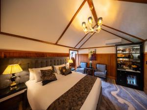 a bedroom with a large bed and a chandelier at Hana Lodge in Rotorua