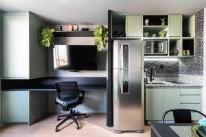 een keuken met een koelkast en een bureau met een stoel bij MV63 - Studio Lindo com Piscina Próx ao Metrô Brás in Sao Paulo