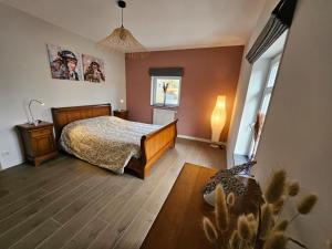 a bedroom with a bed and a table and a window at Les Secrets du Bois in Vielsalm