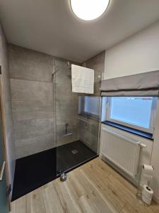 a small bathroom with a shower with a window at Les Secrets du Bois in Vielsalm