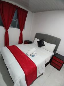 ein Schlafzimmer mit einem großen Bett mit einer roten Decke in der Unterkunft HOTEL ISMAEL de la VILLA in Tinjacá