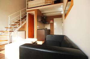 a living room with a black couch and a staircase at Puerto Delta in Tigre