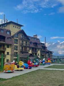 a group of children playing on toy cars in a park at Crystal Loft Apartment 212 in Bakuriani