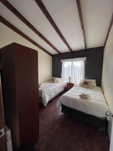 プエルト・ナタレスにあるSHEUEN PATAGONIAのベッド2台と窓が備わる客室です。